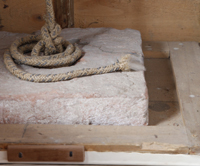 Originalbalk mit Gewichtsstein in der italienischen Prozessionsorgel im Claviersalon Miltenberg